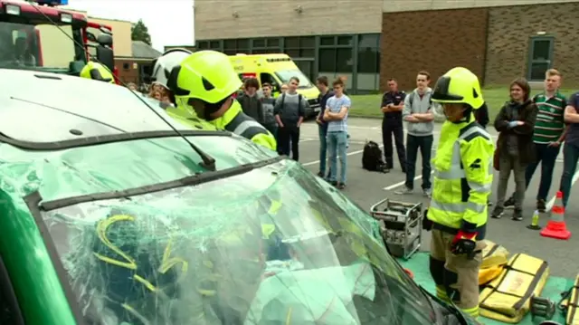 Students looking at crash wreckage