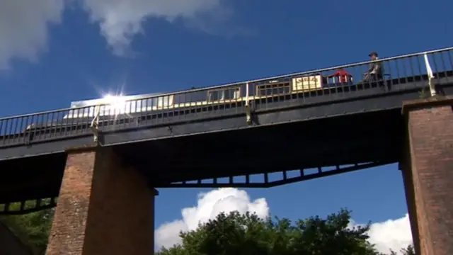 Canal boat goes along aqueduct
