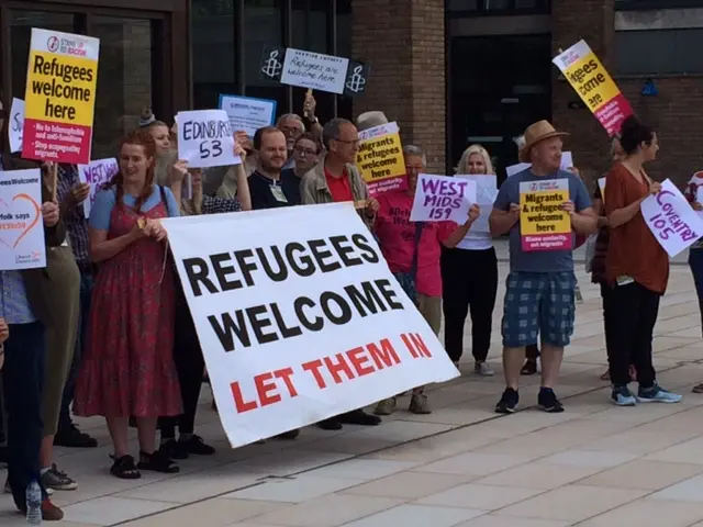 Demonstrators outside County Hall with banners supporting taking in refugees