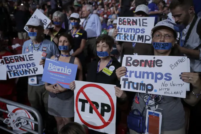 Delegates and attendees hold signs in support of Sen. Bernie Sanders on the first day of the Democratic National Convention in Philadelphia.