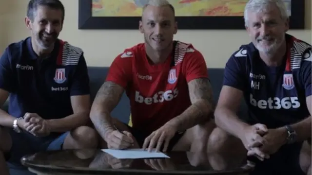 Marko Arnautovic alongside Tony Scholes and manager Mark Hughes