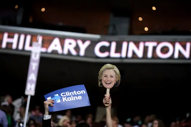 Delegates at the Democratic convention wave posters depicting Mrs Clinton's face