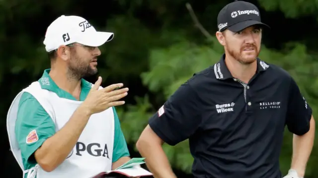 Jimmy Walker talks to his caddie