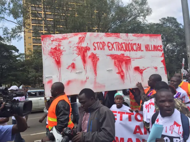People holding banners protesting police killings in Kenya