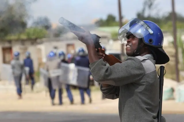 Policeman firing tear gas