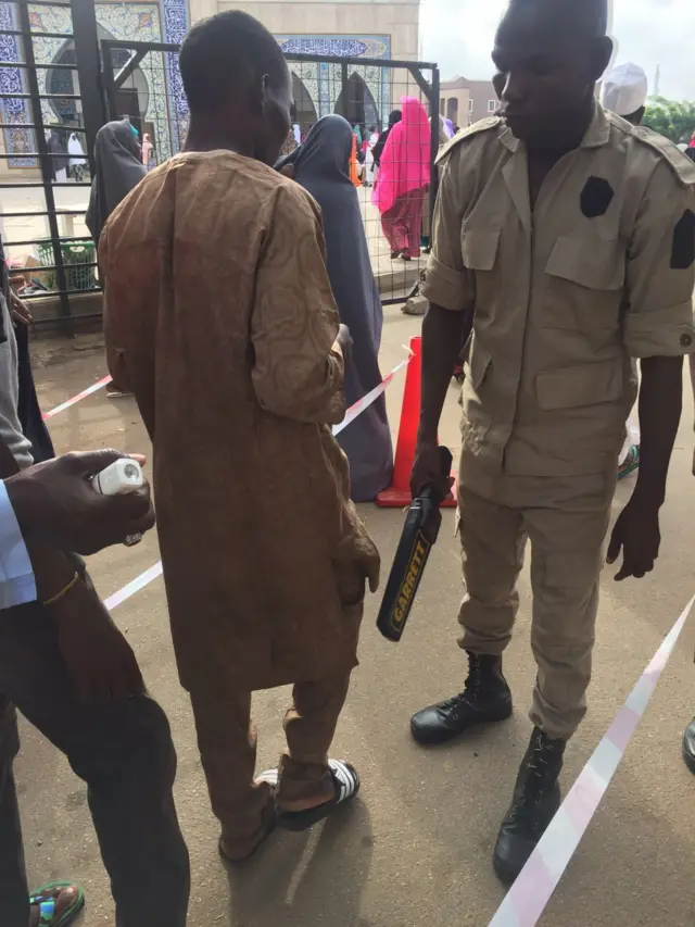 A security guard screening someone at a prayer ground in Nigeria's capital, Abuja