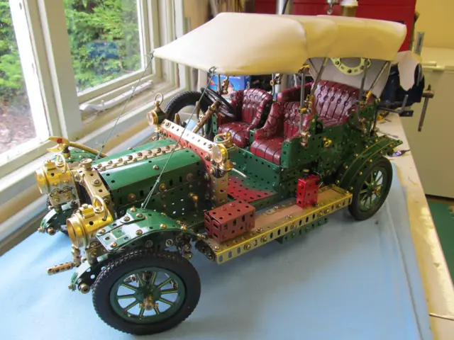 Meccano model of 1907 Armstrong Whitworth car in green with gold trim and red leather seats
