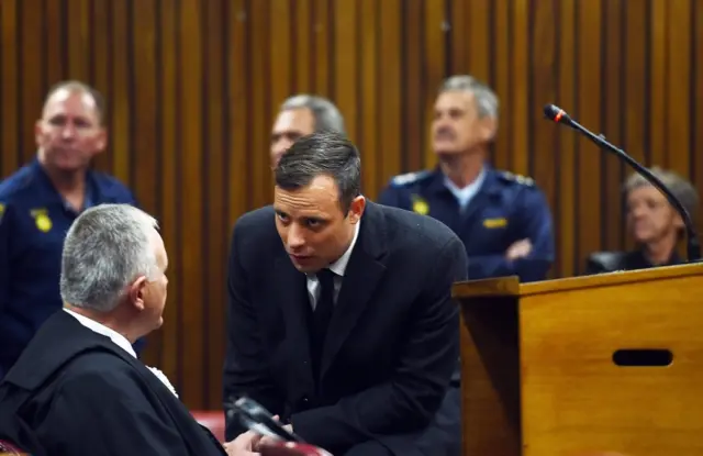 Oscar Pistorius talking to his lawyer in court