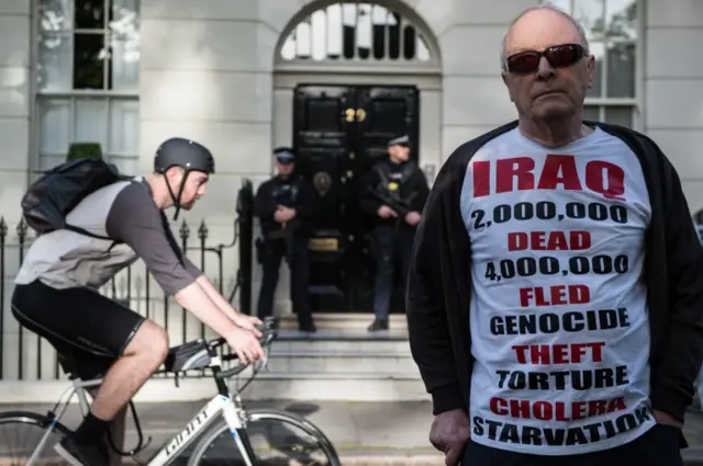 A demonstrator wearing a t-shirt detailing the number of dead in Iraq stands outside the London home of Tony Blair