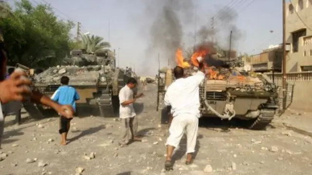 Iraqis set fire to tank