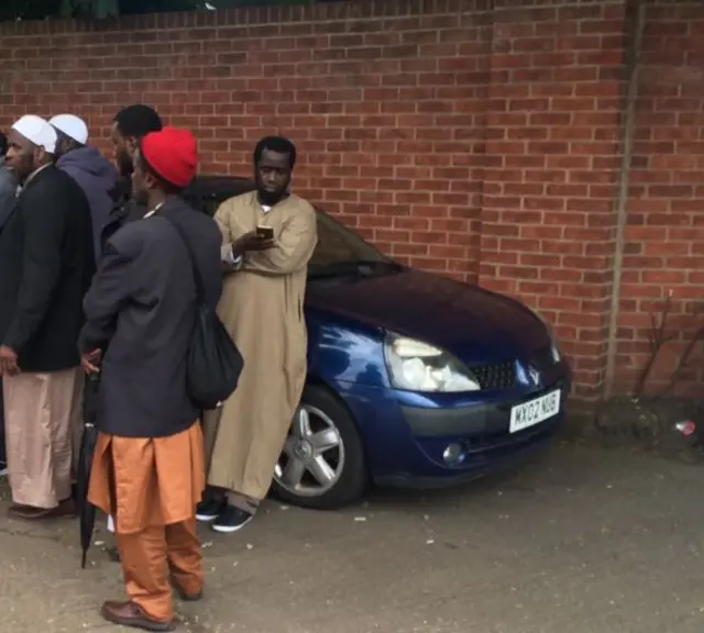 Men gather around killed worker's car