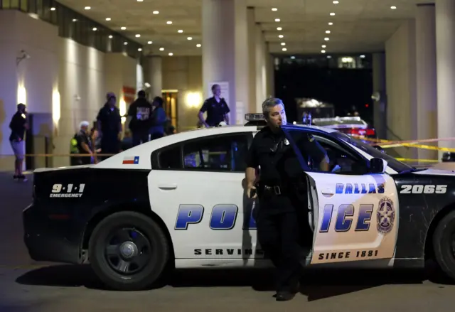 A Dallas police officer steps out of a vehicle as he arrives in front of Baylor University Medical Center where several others were police were already gathered, Friday, July 8, 2016