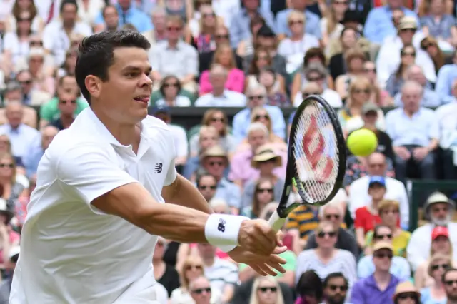 Milos Raonic returns a shot