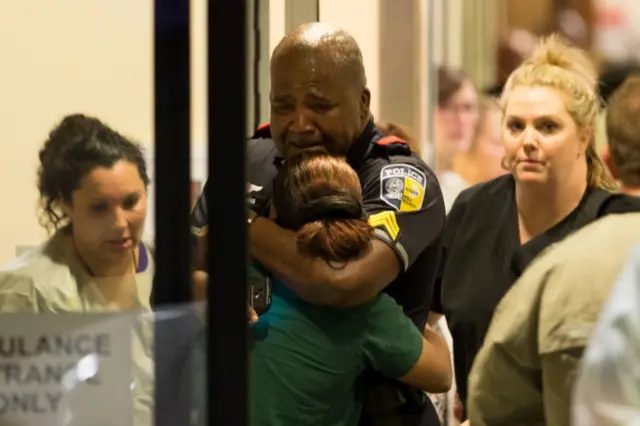 (Dallas Area Rapid Transit) police officer receives comfort at Baylor University Hospital emergency room entrance after a shooting attack in Dallas, Texas,