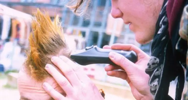 Man using clippers to create punk-style haircut