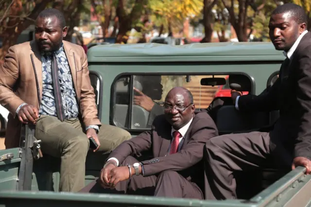 Douglas Mahiya (C), information secretary of the Zimbabwe National Liberation War Veterans Association (ZNLWVA) sits handcuffed in an unmarked police vehicle after a court appearance in Harare, Zimbabwe, 29 July 2016.