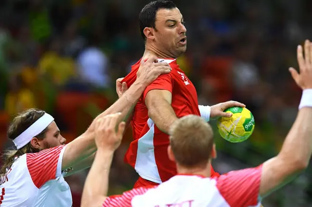 Denmark's left back Mikkel Hansen (L) challenges Tunisia's right back Aymen Hammed