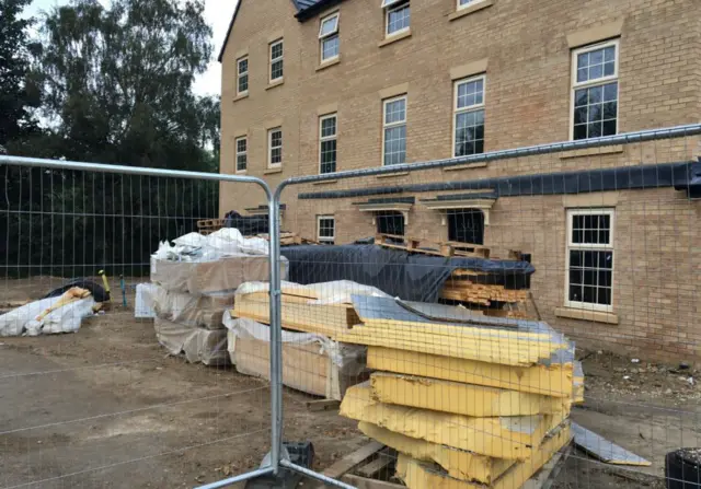 Builders pallets piled up outside newly built homes