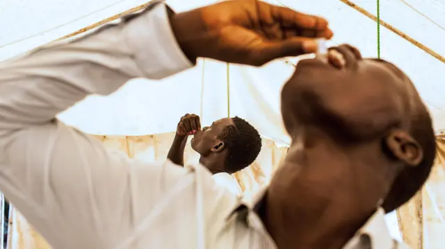 Young men get their dose of oral cholera vaccine inside a tent of the United Nation Mission in South Sudan (UNMISS), at their Tongping base in the South Sudan capital, Juba, on March 1, 2014.