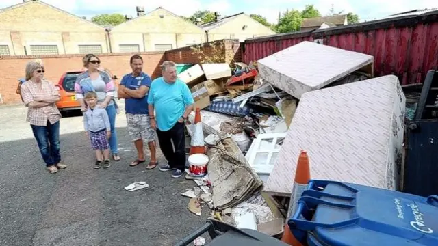 Residents Annette Village, Becky Hunt, Seb Hunt, Craig Walker and Grahame Wood stand next to the pile of rubbish in Offa Street.