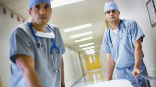 Doctors with trolley in corridor