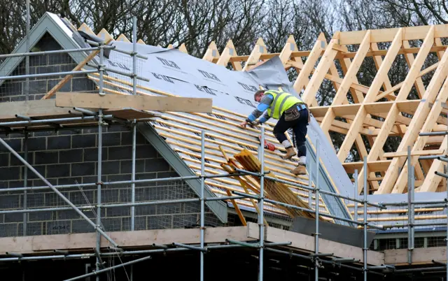 House builder working on a roof
