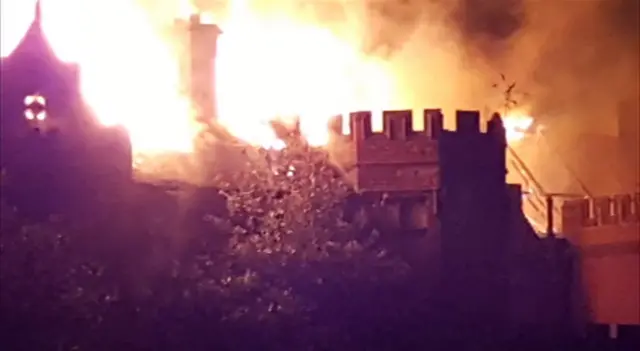 The Old Plumstead Hall on fire, silhouetted against night sky