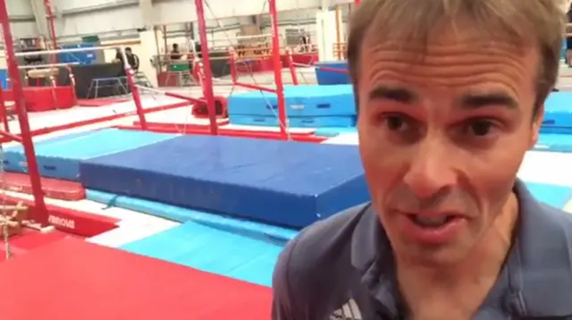 Paul Hall stands in front of gymnastics equipment