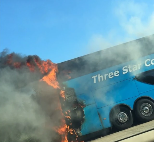 Fire engulfing the rear of a blue coach