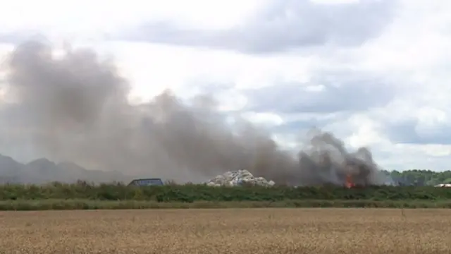 Scrapyard fire, showing piles of waste, flames and smoke