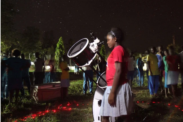 A girl looks at the night sky during one of Travelling Telescope’s astronomy sessions.