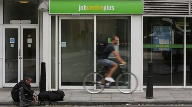 Man cycling past job centre