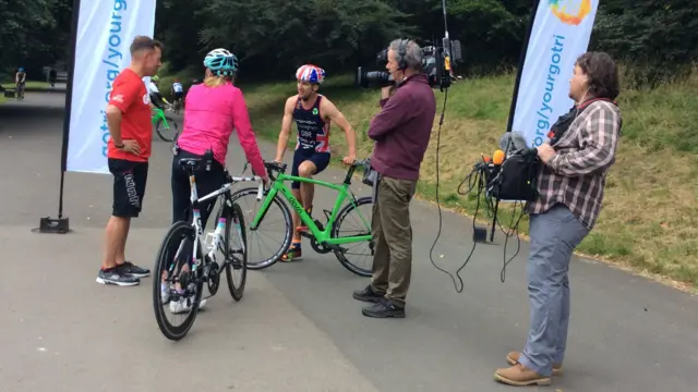 Louise Minchin with crew filming with triathletes on bikes