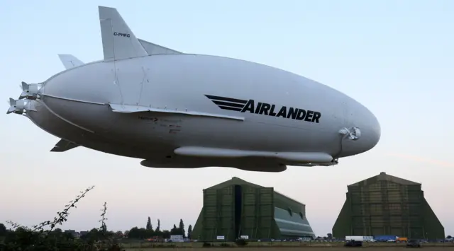 Airlander in flight and Cardington Sheds in background