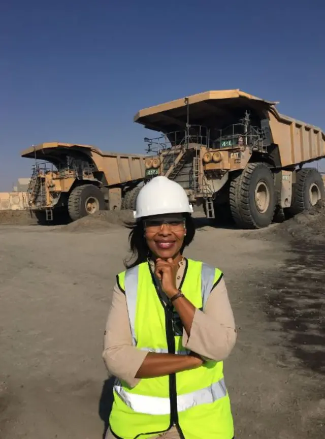 lerato mbele stands in front of massive mining truck