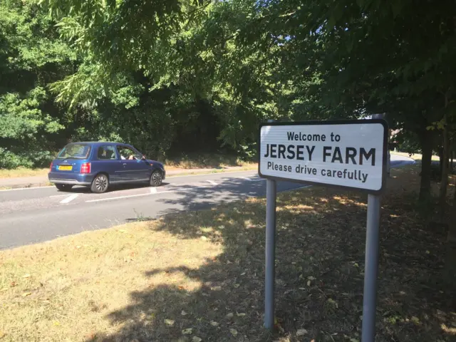 Jersey Farm sign and car on road