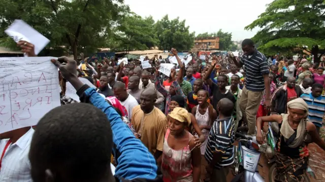 crowd of protesters, some holding placards calling for release of Ras Bath