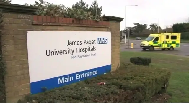 Exterior of entrance to James Paget hospital, showing ambulance and signage