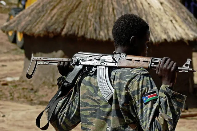 A Sudan People's Liberation Army (SPLA) soldier holds a gun at a containment site outside Juba on April 14, 2016.