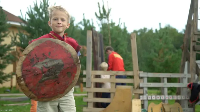 A child stands with a shield