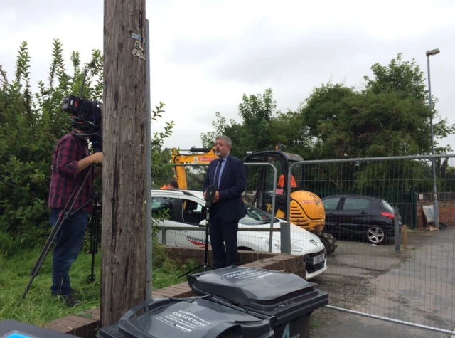 Phil Mackie near some wheelie bins