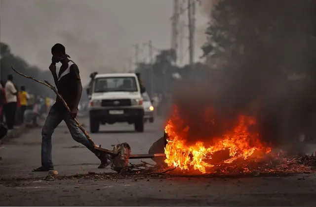 rotestors opposed to the Burundian president Pierre Nkurunziza's third term in office gather by a burning barricade during a demonstration in the Cibitoke neighborhood of Bujumbura on May 19, 2015.