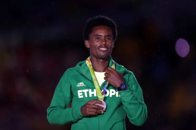 Silver medalist Feyisa Lilesa of Ethiopia stands on the podium during the medal ceremony for the Men"s Marathon during the Closing Ceremony on Day 16 of the Rio 2016 Olympic Games at Maracana Stadium on August 21, 2016 in Rio de Janeiro, Brazil.