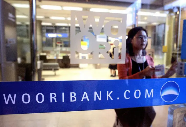 A South Korean woman leaves a branch of Woori Bank in Seoul