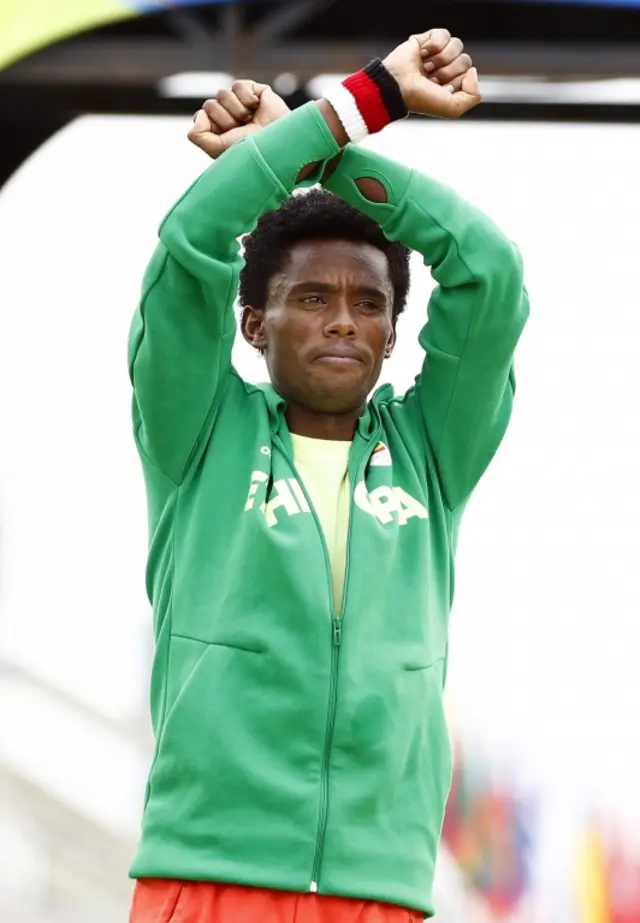 Feyisa Lilesa of Ethiopia celebrates on the podium after winning th silver medal in the men"s Marathon race of the Rio 2016 Olympic Games Athletics