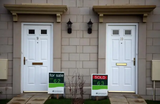 'For sale' and 'sold' signs are displayed outside new build houses on a housing estate by developer and housebuilder Persimmon