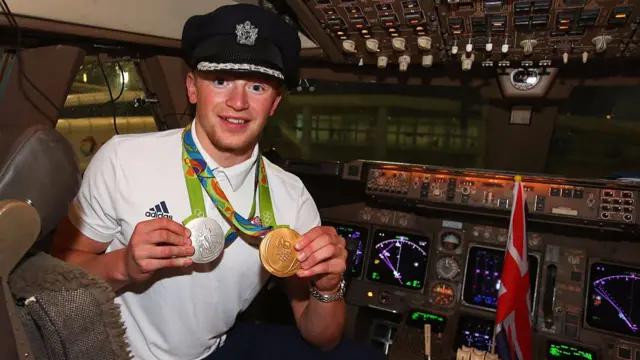 Adam Peaty of Great Britain poses with his medals in the flight deck