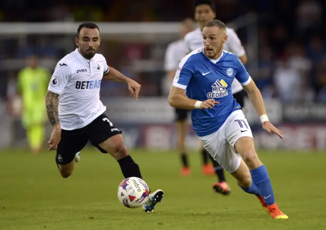 Peterborough United's Marcus Maddison in action with Swansea City's Leon Britton