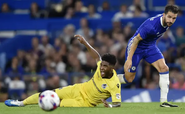 Bristol Rovers' Ellis Harrison in action with Chelsea's Cesc Fabregas