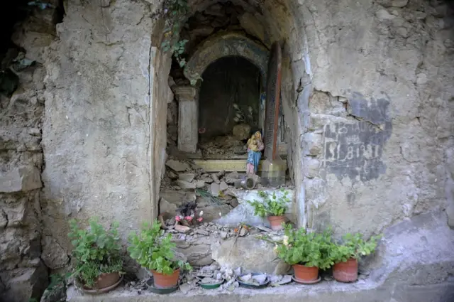 A Virgin Mary statue stands amid debris in the central Italian town of Pescara del Tronto